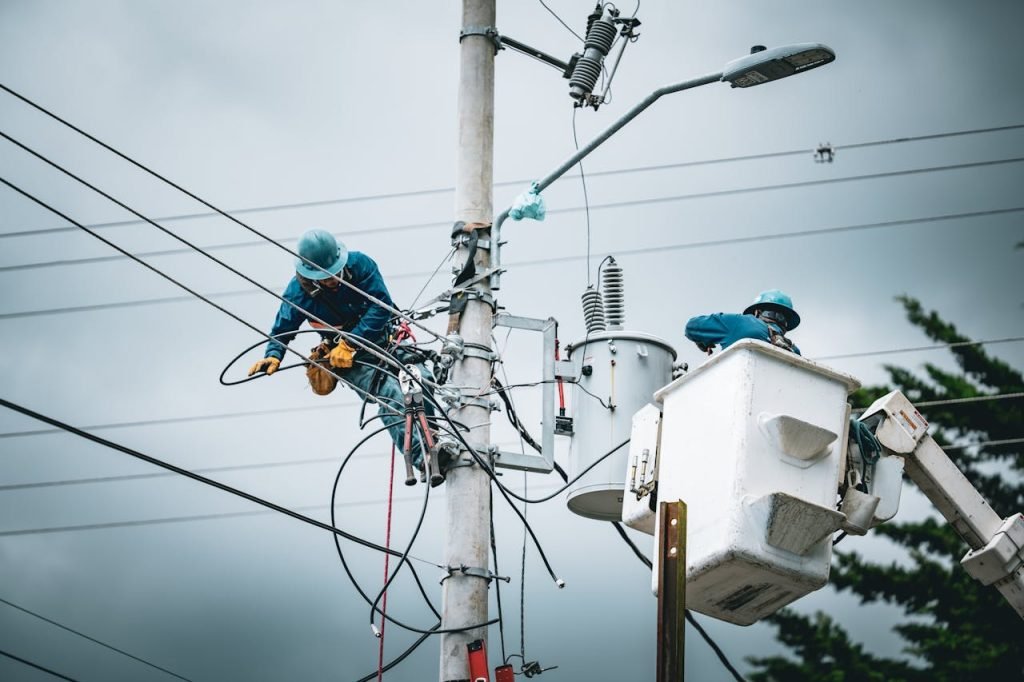Electricians in San José, Costa Rica, repairing power lines from a cherry picker.